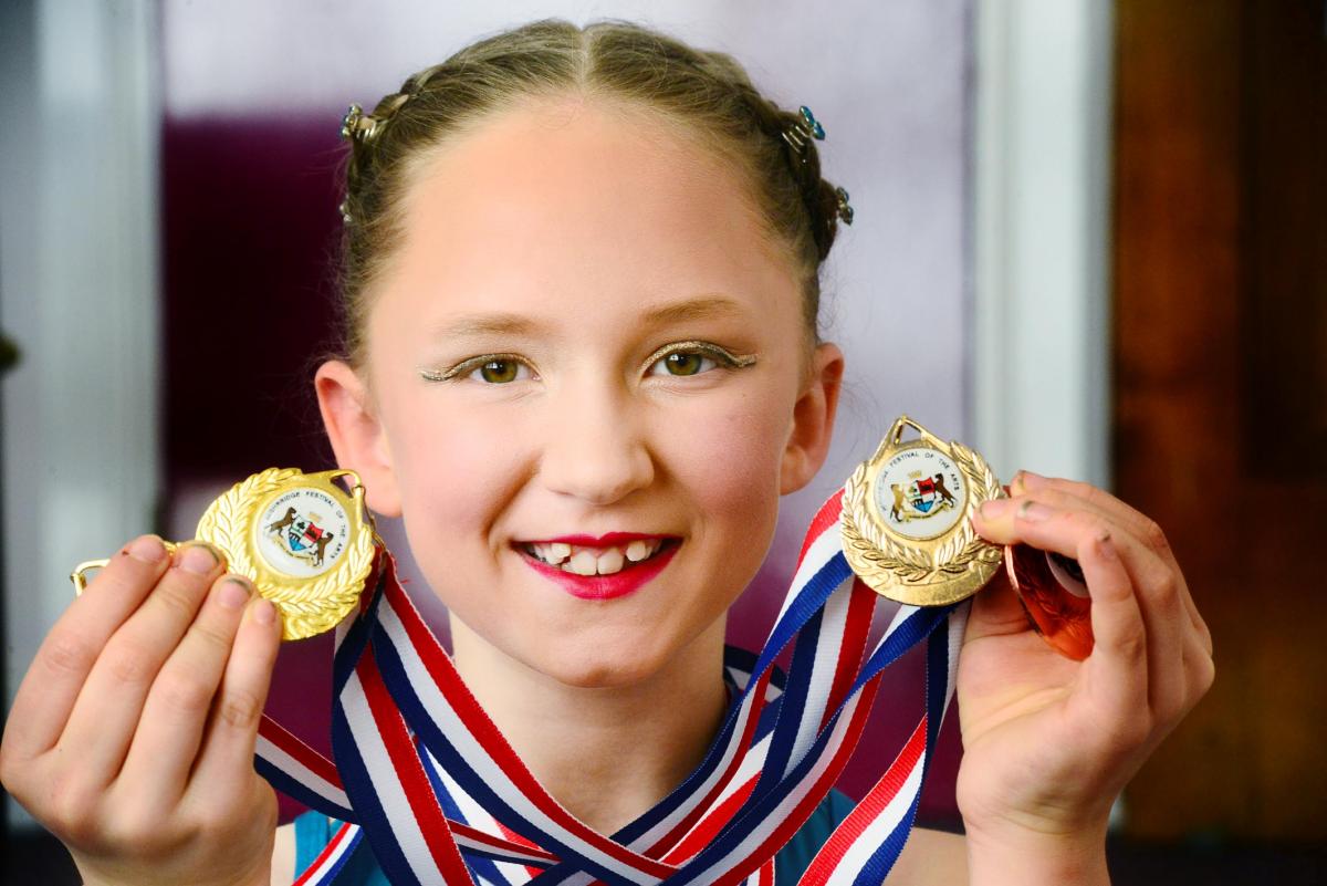 SMILES: Alex Thomas smiles with her dance medals