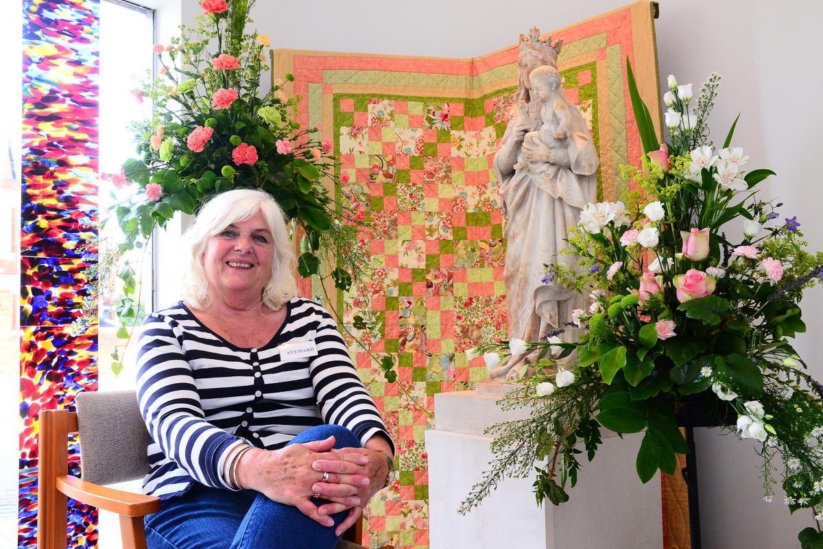 SMILES:Jan Vaughan sits proudly next to the colourful quilt